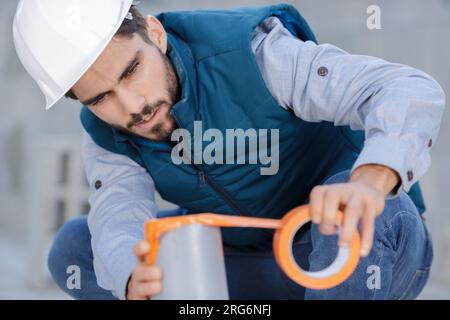 un lavoratore misura un tubo Foto Stock