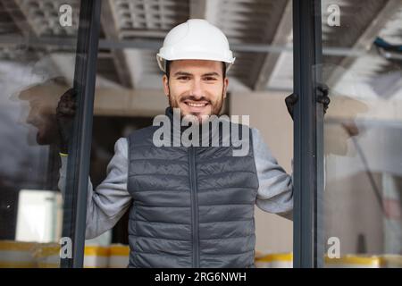 operaio edile che installa una nuova finestra in casa Foto Stock