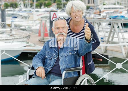 coppia anziana in sedia a rotelle durante le vacanze Foto Stock