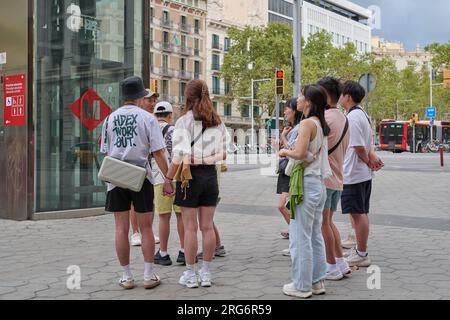 04.08.2023. Barcellona, ​​​​Spain, piccolo gruppo di turisti orientali in pieno passeig de gracia Foto Stock