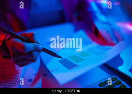 Primo piano sulla donna moderna con documenti che lavorano con grafici. Foto Stock