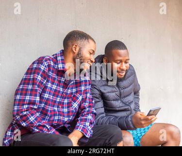 Amici maschi felici con il telefono a casa. Adolescenti che utilizzano i social media Foto Stock