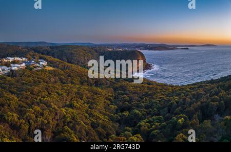 Vista dell'alba sul mare e sulla foresta dal Captain Cook Lookout a Copacabana, sulla costa centrale del New South Wales, Australia. Foto Stock