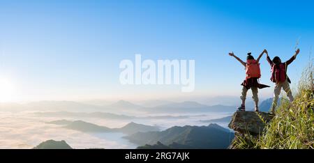 Un gruppo di escursionisti felici ha alzato le armi sulla montagna. scalatori di successo Foto Stock