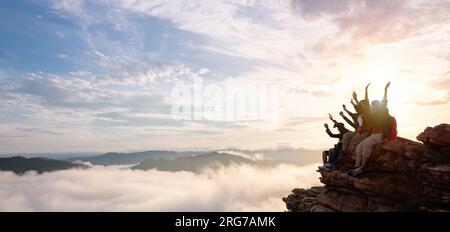 Gruppo di escursionisti felici ha alzato le braccia sulla collina. scalatori di successo Foto Stock