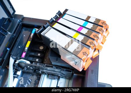 Primo piano delle cartucce di inchiostro nuove posizionate su una stampante a getto d'inchiostro pronta per l'installazione. Foto Stock