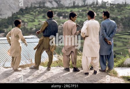 Gilgit, Pakistan - 30 giugno 1987: Uomini pakistani a Karakoram Highway in abito locale guardare la valle e discutere a Gilgit, Pakistan. Il Karakoram Ciao Foto Stock