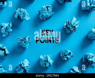Messaggio punti chiave con palline di carta blu schiacciate su sfondo blu. I punti o gli aspetti più importanti di una questione. Foto Stock