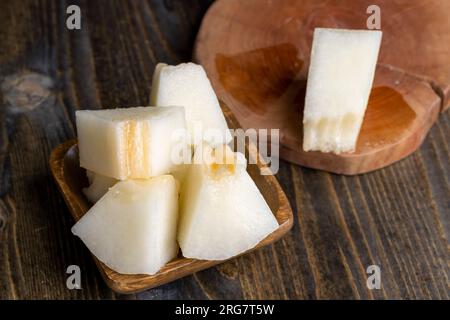 Melone maturo e dolce a fette, delizioso melone tagliato a pezzi su una superficie di legno Foto Stock