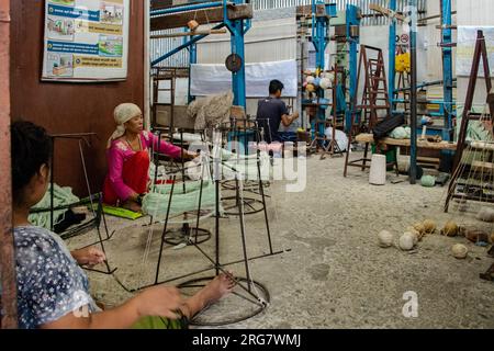 Filati e tessitori in una fabbrica di tappeti a Jorpati, Kathmandu, Nepal. Foto Stock