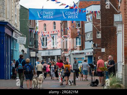 Turisti e concorrenti camminano lungo High Street durante la Cowes Week, la famosa regata annuale di yachting - Cowes, Isola di Wight, Hampshire, Inghilterra Foto Stock