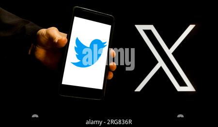 Botswana, Gaborone 8 agosto 2023, editoriale, foto dello schermo del computer con il nuovo logo x twitter e uomo davanti con la mano che tiene un telefono con l'ingegno Foto Stock