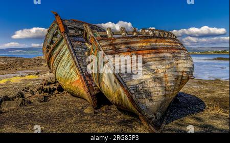 Vecchie barche da pesca in legno naufragate sul lato del mare, Isola di Mull Foto Stock