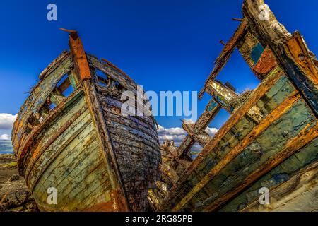 Vecchie barche da pesca in legno naufragate sul lato del mare, Isola di Mull Foto Stock