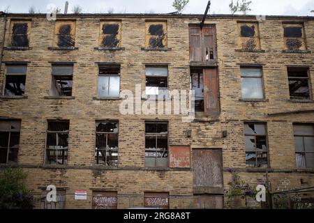 Facciata della vecchia fabbrica abbandonata con finestre rotte nelle strade secondarie di Bradford, Yorkshire, Inghilterra, Regno Unito. 2023 Foto Stock