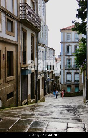 I turisti in una giornata umida di giugno in una strada pedonale del centro storico Santiago de Compostela Galizia Spagna Foto Stock