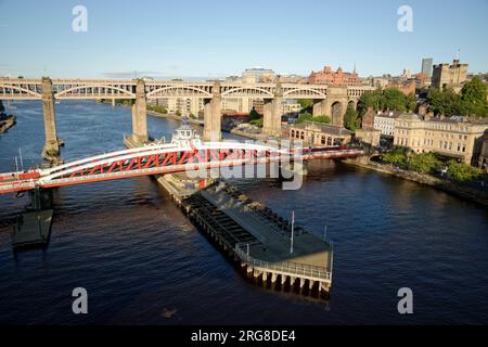 Lo Swing Bridge a Newcastle. Ponte stradale in metallo dipinto di rosso e bianco sul fiume Tyne. Il ponte di alto livello dietro di esso. Foto Stock