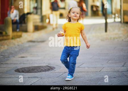 Adorabile bambina che si diverte in una strada della città medievale di Quimper, Bretagna, Francia. Bambini felici all'aperto. Foto Stock