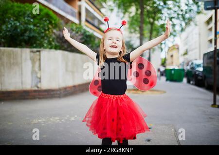 Allegra bambina in età prescolare in costume da coccinella in una strada di Parigi, in Francia Foto Stock