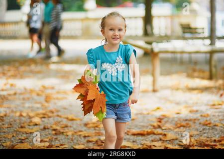 Adorabile bambina in età prescolare che si gode una bella e soleggiata giornata autunnale all'aperto Foto Stock