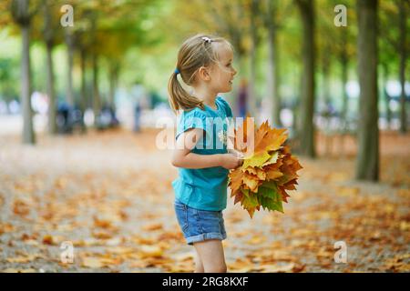 Adorabile bambina in età prescolare che si gode una bella e soleggiata giornata autunnale all'aperto Foto Stock