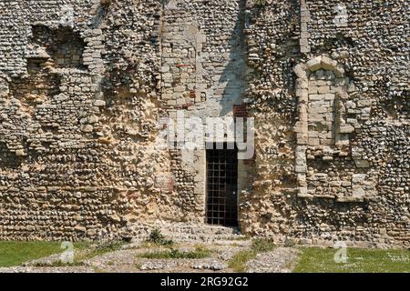 Vista ravvicinata della variegata muratura del castello di Portchester, vicino a Portsmouth, Hampshire, che mostra come l'edificio sia stato aggiunto nel corso dei secoli. Costruito come forte romano alla fine del III secolo, divenne un castello normanno nel XII secolo, Riccardo II ne trasformò parte in un palazzo nel 1396, e Enrico V partì da qui nel 1415. Foto Stock