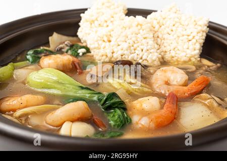 Zuppa di riso glutinosa fritta con frutti di mare su sfondo bianco Foto Stock