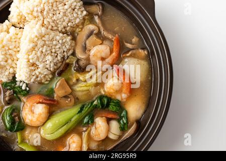 Zuppa di riso glutinosa fritta con frutti di mare su sfondo bianco Foto Stock