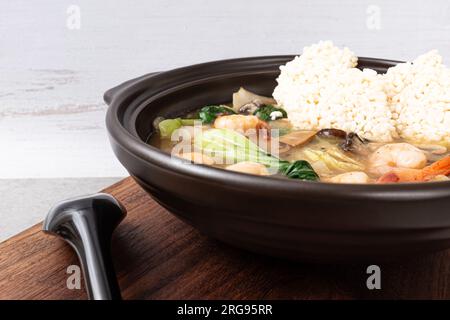 Zuppa di riso glutinosa fritta di pesce con frutti di mare e verdure e riso glutinoso fritto Foto Stock