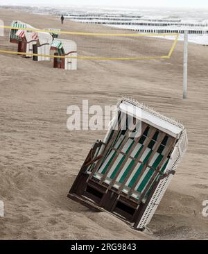 8 agosto 2023, Meclemburgo-Pomerania Occidentale, Graal-Müritz: La spiaggia del Mar Baltico è quasi deserta, il vento degli ultimi giorni ha causato l'inclinazione di una sdraio. Il vento forte e la pioggia hanno allontanato i vacanzieri. Foto: Bernd Wüstneck/dpa Foto Stock