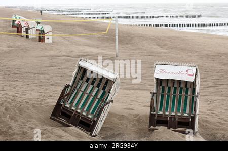 8 agosto 2023, Meclemburgo-Pomerania Occidentale, Graal-Müritz: La spiaggia del Mar Baltico è quasi deserta; il vento degli ultimi giorni ha causato il disagio di due sdraio. Il vento forte e la pioggia hanno allontanato i vacanzieri. Foto: Bernd Wüstneck/dpa Foto Stock