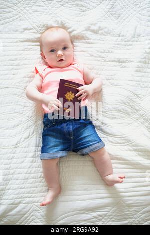 Bambina di sei mesi sdraiata sulla schiena e con passaporto francese Foto Stock