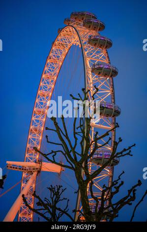 LONDRA - 22 aprile 2023: Lo skyline di Londra rende un vibrante tributo culturale in occasione dello Stephen Lawrence Day, l'iconico London Eye illuminato in sfumature arancioni. Foto Stock