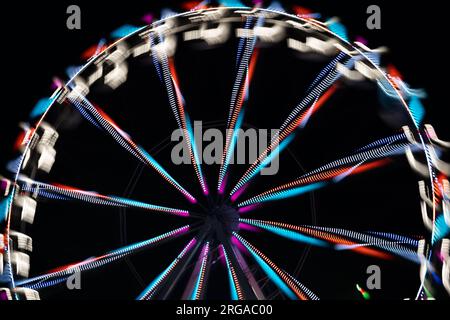 moderna ruota panoramica con cabine chiuse al carnevale con cielo blu senza nuvole sullo sfondo ripresa ravvicinata con grandangolo illuminato Foto Stock