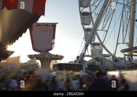 moderna ruota panoramica con cabine chiuse al carnevale con cielo blu senza nuvole sullo sfondo ripresa ravvicinata con grandangolo illuminato Foto Stock