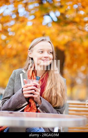 Ragazza che beve vino caldo in un caffè Foto Stock