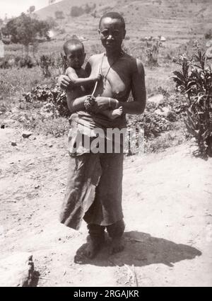 1940s Africa orientale - Uganda - Gruppo tribale di Chigga - fotografia di donna e bambino di un ufficiale di reclutamento dell'esercito britannico di stanza in Africa orientale e in Medio Oriente durante la seconda guerra mondiale Foto Stock