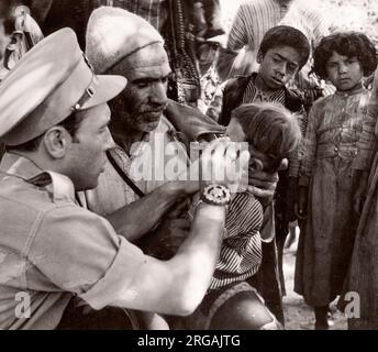 1943 Siria - l'ufficio militare britannico tratta i curdi lungo il confine con la Siria Turchia - molti soffrono di Trachoma fotografia di un ufficiale di reclutamento dell'esercito britannico di stanza in Africa orientale e in Medio Oriente durante la seconda guerra mondiale Foto Stock