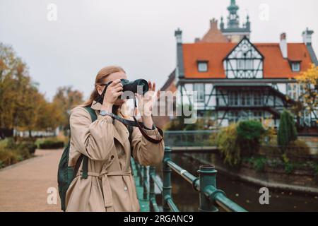 La vera visione di una giovane turista europea in cappello realizza foto o video nella città di Danzica, in Polonia Foto Stock