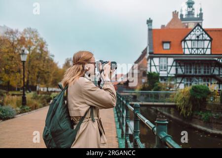 La vera visione di una giovane turista europea in cappello realizza foto o video nella città di Danzica, in Polonia Foto Stock