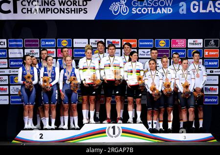 Stefan Bissegger, Stefan Kung, Mauro Schmid, Elise Chabbey, Nicole Koller e Marlen Reusser (gruppo centrale) festeggiano sul podio dopo aver vinto l'oro nel Team Time Trial Mixed Relay insieme ai francesi Bruno Armirail, Remi Cavagna, Bryan Coquard, Audrey Cordon-Ragot, Cedrine Kerbaol e Juliette Labous (gruppo di sinistra), che ha vinto l'argento e il tedesco Miguel Heidemann, Jannik Steimle, Max Walscheid, Ricarda Bauernfeind, Lisa Klein e Franziska Koch, che ha vinto il bronzo, il sesto giorno dei Campionati del mondo di ciclismo UCI 2023 a Glasgow. Data foto: Martedì 8 agosto 2023. Foto Stock