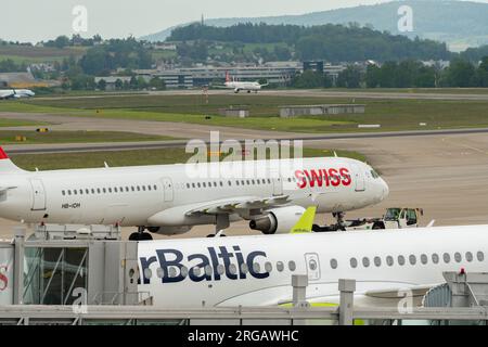 Zurigo, Svizzera, 19 maggio 2023 HB-IOH compagnie aeree internazionali svizzere Airbus A321-111 viene trainato attraverso il piazzale dietro un Bombardi Air Baltic Foto Stock