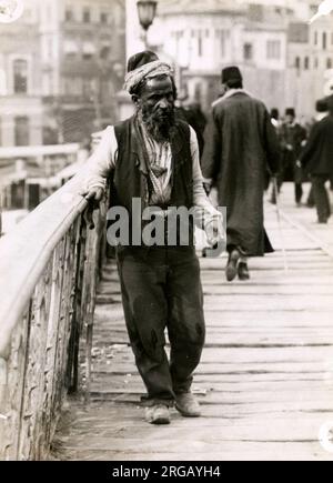 Un mendicante cieco su un ponte in Costantinopoli Istanbul Turchia c.1920s Foto Stock