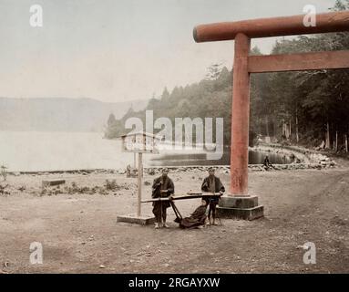 Fotografia d'epoca del XIX secolo - epoca Meiji Giappone: torri, sedia da trasporto, sedia berlina, sulla riva del lago Hakone. Foto Stock