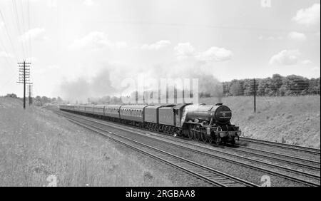 4472 'Flying Scotsman', una locomotiva LNER classe A3, sulla linea principale, a velocità, circa 1967. LNER Class A3 4472 'Flying Scotsman' è una locomotiva a vapore del Pacifico 4-6-2, costruita nel 1923 per la London and North Eastern Railway (LNER) presso Doncaster Works su progetto di Nigel Gresley. Fu impiegato sui treni a lunga distanza Express East Coast Main Line dalla LNER e dai suoi successori, British Railways Eastern e North-Eastern Regions, in particolare sul servizio ferroviario Flying Scotsman da Londra a Edimburgo, da cui fu chiamato. Foto Stock