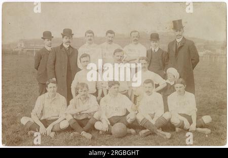 Cook's Football Team, località sconosciuta, foto di gruppo su un campo sportivo con quattro uomini ben vestiti e un bambino. Foto Stock