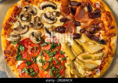 Pizza italiana Four Seasons con pomodoro olive funghi e carciofi Foto Stock