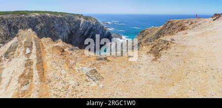 Visitatore femminile che contempla le scogliere della costa di Cabo Sardao, Ponta do Cavaleiro, Sao Teotonio, Portogallo Foto Stock