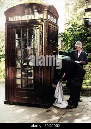 Un nuovo chiosco telefonico in uso in una via londinese, che mostra un chiamante all'interno, francobolli acquistati dalla macchina all'esterno, e un postino che raccoglie la posta dalla cassetta delle lettere. Foto Stock