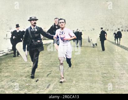 John Hayes, atleta americano, nella tappa finale della maratona ai Giochi Olimpici di Londra del 1908. Dorando Pietri d'Italia crollò dopo essere entrato nello stadio davanti al pack. Fu ravvivato dai medici e alcuni dei funzionari lo aiutarono ai piedi e poi lo aiutarono fino al traguardo. John Hayes degli Stati Uniti è stato il secondo finisher. Pietri era stato dichiarato vincitore, ma gli americani hanno presentato una protesta che è stata finalmente confermata. A Dorando fu comunque presentata una coppa speciale della regina Alexandra per il suo 'pluck'. Foto Stock